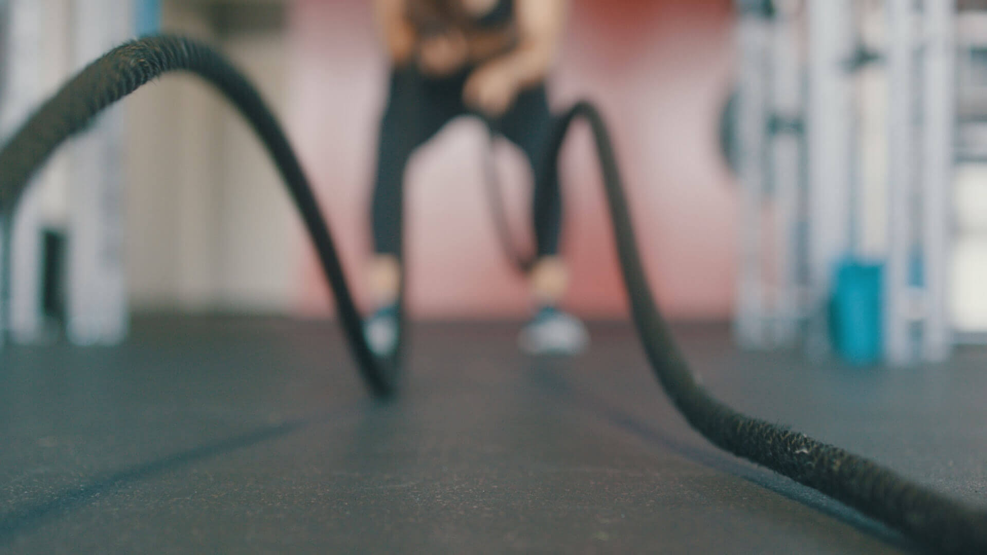 A person engaged in a workout, energetically using ropes for exercise at the gym.